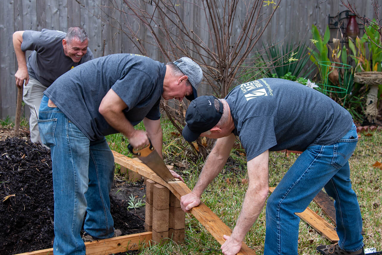 Men sawing a piece of wood