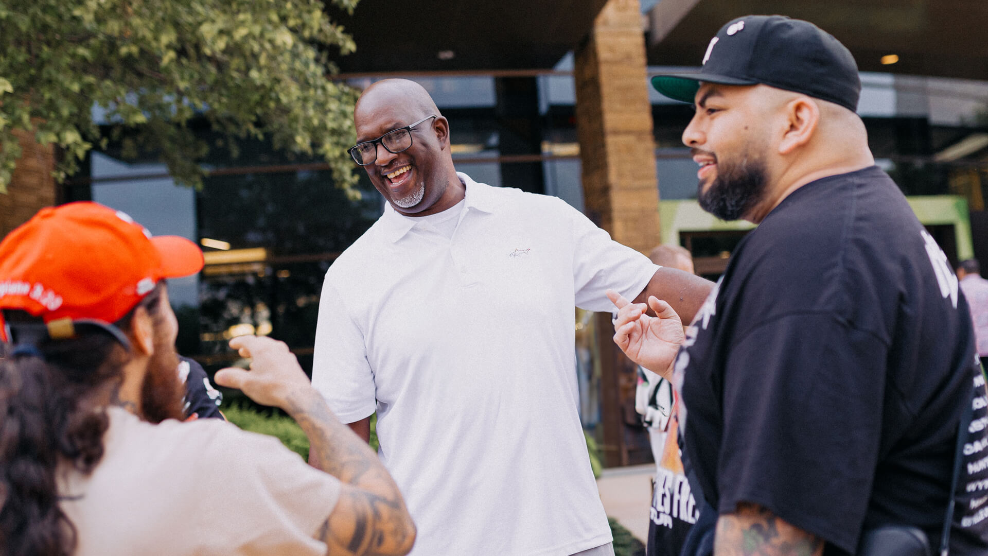 Un hombre sonriendo y hablando con sus amigos