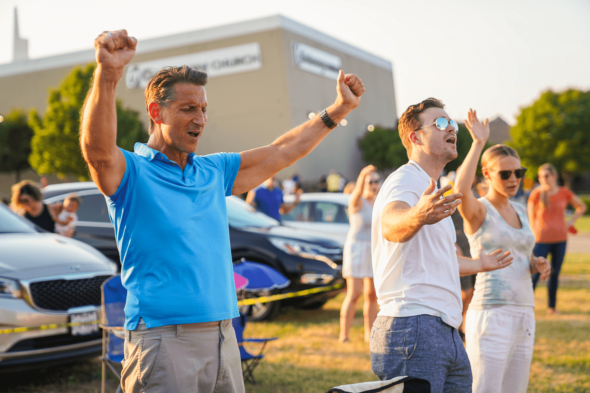 People worshipping outdoors with hands raised
